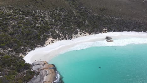 Drone-aerial-panning-to-reveal-2-beaches-with-blue-water-and-white-sand