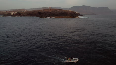 Majestät-In-Den-Höhen:-Leuchtturm-Punta-De-Sardina-In-Galdar,-Gran-Canaria-Und-Kleines-Boot-Bei-Sonnenuntergang