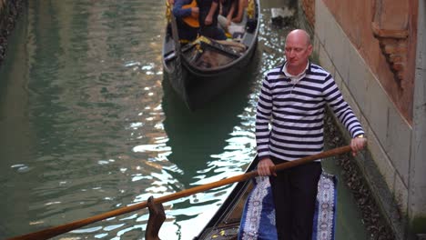 Gondoliers-with-striped-shirts-sails-gondolas-in-one-of-many-water-canals-in-Venice