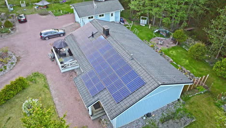 AERIAL:-rising-in-front-of-a-family-eco-home,-powered-by-phovoltaic-energy