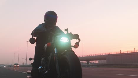 Un-Motociclista-Recorre-La-Ciudad-De-Abu-Dhabi-Mientras-Las-Carreteras-Están-Vacías,-Una-Motocicleta-Negra-Con-Un-Conductor-Realiza-Un-Recorrido-Aventurero-Por-La-Ciudad-De-Abu-Dhabi,-En-Dirección-A-Dubai.