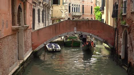 Gondel-Schwimmt-Unter-Steinbogenbrücke-In-Venedig