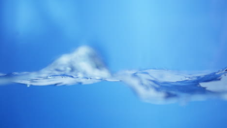 Zeitlupe-Von-Wasserwellen-Auf-Der-Oberfläche-Mit-Blauem-Hintergrund