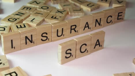 Closeup-narrow-focus-Scrabble-game-tiles-form-words-INSURANCE-and-SCAM