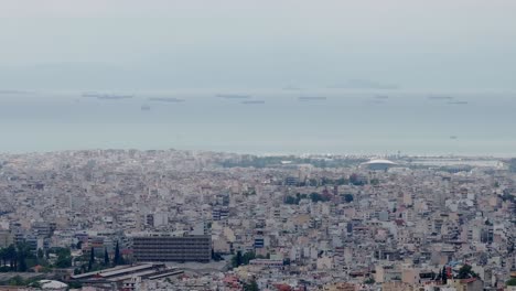 telephoto-aerial-drone-fly-over-city-of-Athens-,-cloudy-moody-day-panoramic-view-of-sea-and-buildings