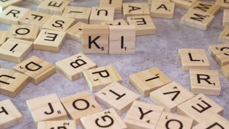 Right-hand-places-Scrabble-tile-letters-on-table-to-form-word-KING