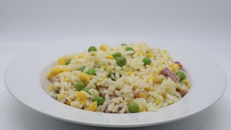 Arroz-Cantonés-Sobre-Plato-Giratorio,-Fondo-Blanco