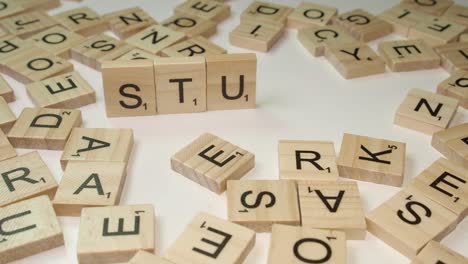 Scrabble-Fliesen-Buchstaben-Auf-Rand-Bilden-Wortstudie-Auf-Weißer-Tischplatte