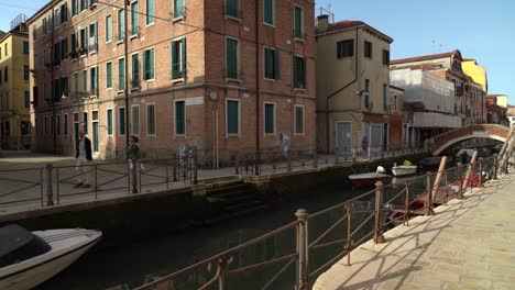 Elderly-Couple-Walks-among-the-water-Canal-in-Venice