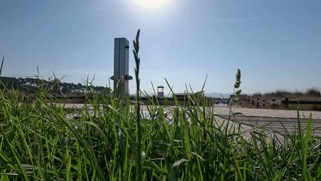 Hinter-Dem-Gras-Befindet-Sich-Ein-Springbrunnen,-Um-Den-Sand-Vom-Strand-Auf-Die-Holzplattform-Zu-Waschen