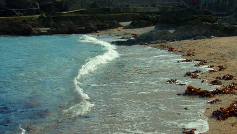 Medium-to-wide-shot-of-waves-was-they-meet-the-beach-on-an-Irish-coastline