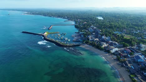 Toma-Aérea-De-Drones-De-La-Pared-De-Rotura-De-La-Entrada-Del-Canal-Del-Océano-Arenoso-Con-Barcos-Atracados-En-El-Arrecife-Cerca-De-La-Ciudad-De-Turtle-Beach-En-Hikkaduwa,-Sri-Lanka,-Asia,-Viajes,-Turismo-Marino.