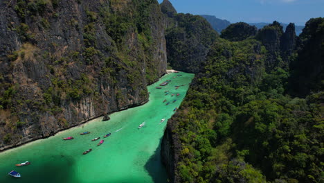 Long-tail-boats-arriving-to-emerald-green-Pileh-lagoon,-Phi-Phi