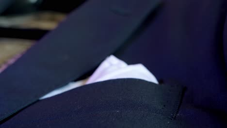 Slow-revealing-shot-of-a-white-pocket-square-folded-in-the-grooms-suit-jacket