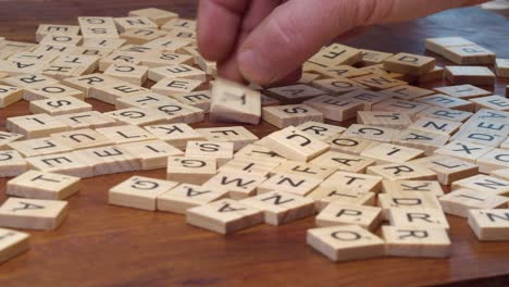 Close-up-select-focus:-Scrabble-game-letter-tiles-on-wooden-desk-top