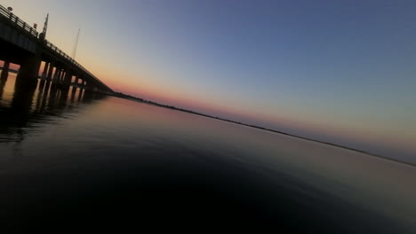 FPV-Webcam-Zwischen-Brückenpfeilern-Bei-Sonnenuntergang-über-Der-Bucht-Von-New-Jersey