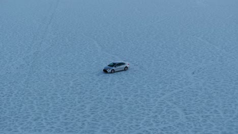 Isolated-vehicle-driving-in-Bonneville-Salt-Flats,-Utah