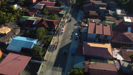 Cars-driving-on-streets-of-San-Pablo,-Laguna,-sunny-evening-in-the-Philippines---Aerial-view