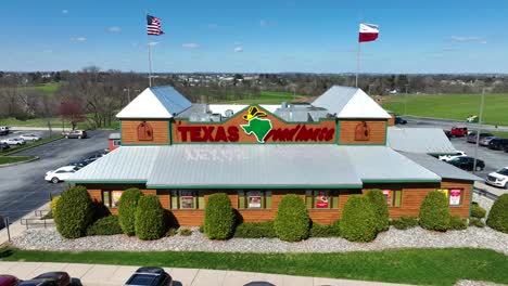 Aerial-view-of-Texas-Road-House-with-waving-american-flag-on-roof-of-building-in-USA