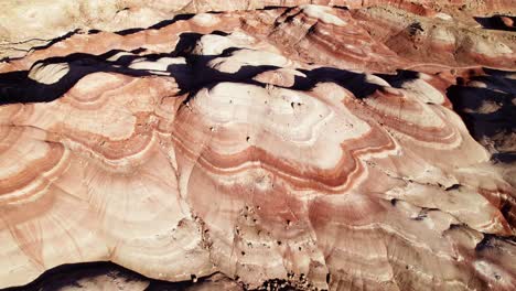 Aerial-4k-drone-descending-view-of-Bentonite-Hills,-Utah,-at-golden-hour-colorful-mars-like-landscape