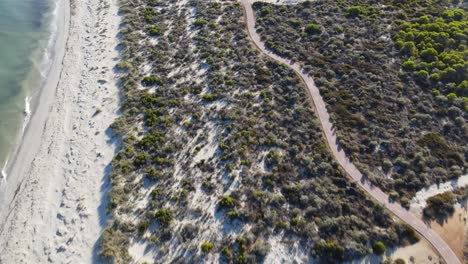 Drohnenaufnahmen-Einer-Laufstrecke-An-Einem-Unberührten-Weißen-Sandstrand-Mit-Viel-Grün