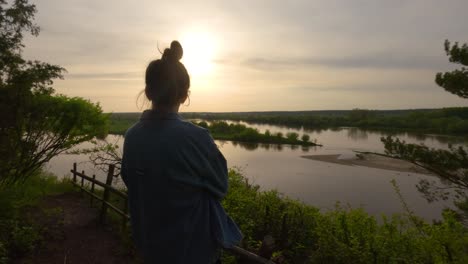 La-Señora-Contempla-La-Puesta-De-Sol-En-El-Tranquilo-Paisaje-Del-Delta-Del-Río-Visto-Desde-Detrás-Del-Embalse-Natural,-Un-Ambiente-Tranquilo-En-La-Campiña-Polaca