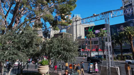 Las-Vegas-Strip-on-Sunny-Winter-Day-Scene,-People-on-Sidewalk,-Boulevard-Traffic-and-Paris-Hotel-Casino