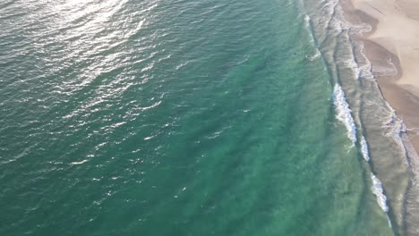 Drone-aerial-panning-up-over-a-beautiful-blue-beach-with-white-sand-in-Western-Australia-during-sunrise