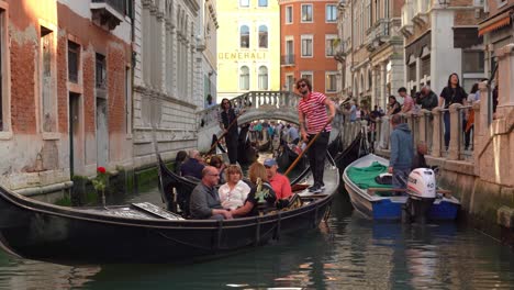 Junger-Venezianischer-Gondoliere-Segelt-Eine-Gruppe-Von-Touristen-In-Einem-Wasserkanal-In-Venedig