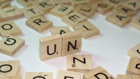 Nahaufnahme-Scrabble-Fliesen-Buchstaben-Bilden-Die-Abkürzung-Der-Vereinten-Nationen-UN-Auf-Dem-Tisch