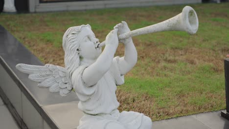 Statue-Eines-Engels,-Der-Eine-Trompete-Spielt,-Mitten-In-Einem-Garten