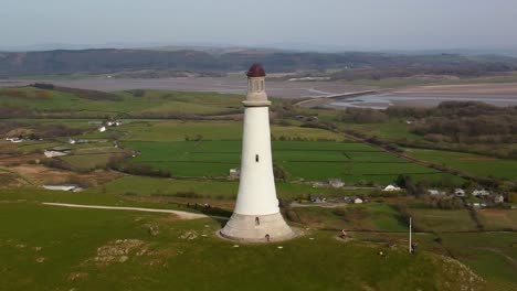 Aerial-circling-shot-around-the-Sir-John-Barrow-Monument,-showcasing-its-isolated-location-atop-a-hill-with-panoramic-views