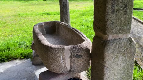 Stone-bowl-basin-carved-and-well-worn-at-corner-of-old-church-property