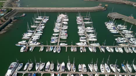 Toma-Aérea-Cenital,-Comenzando-De-Cerca-Y-Alejándose-De-Los-Barcos-En-Un-Puerto-Deportivo-En-Un-Día-Soleado.