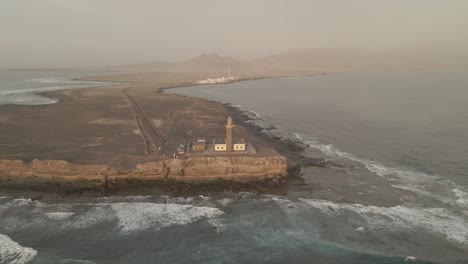 An-aerial-view-reveals-the-splendor-of-a-lighthouse-against-the-vast-ocean—a-spectacular-coastal-vista-that-stirs-the-senses,-offering-a-moment-of-reflection-for-the-beauty-of-the-natural-world