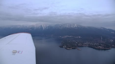 Single-Engine-Airplane-Wing-in-Flight,-Mountain-Coastline-Background