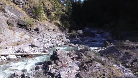 Drones-Vuelan-Sobre-El-Río-Con-Aguas-Cristalinas-De-Color-Turquesa-En-El-Valle-De-La-Montaña-En-Austria,-Europa