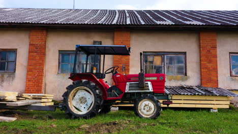 Red-yanmar-m1610d-farming-tractor-with-cabin-outdoors-in-countryside-at-sawmill