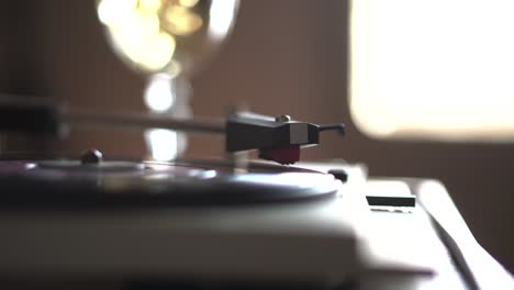 Vintage-Gramophone-Playing-Small-Vinyl-Record-in-Room-Ambience-With-Glass-of-White-Wine-of-Champagne