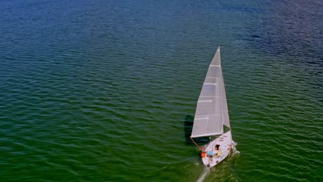 Overhead-View-of-Sailboat-Cruising-on-Green-Waters