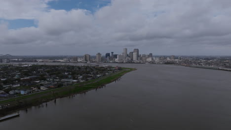 Amplio-Vuelo-Aéreo-Del-Centro-De-Nueva-Orleans-Con-Nubes-Moviéndose-Y-El-Río-Mississippi-Debajo