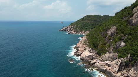 Rocky-cliffs-next-to-stunning-blue-ocean---aerial-drone-shot