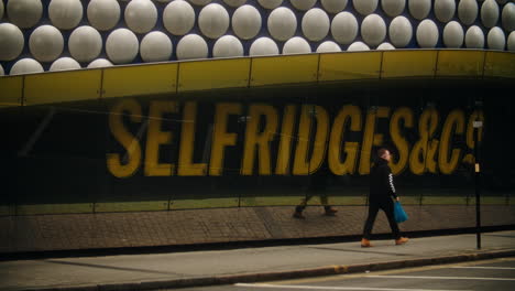 Un-Hombre-Pasa-Por-La-Señalización-De-Selfridges-En-Birmingham,-Reino-Unido