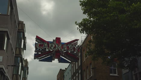 Cartel-De-Carnaby-Colgado-En-El-Aire---Union-Jack,-Carnaby-Street,-Londres,-Día,-ángulo-Bajo-Con-El-árbol