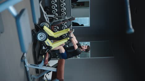 Vertical-video-of-male-at-gym-perform-seated-leverage-low-row-back-exercise