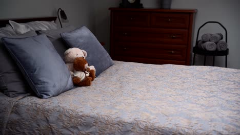 Cozy-furnished-bedchamber-with-a-grey-double-bed-and-two-teddy-bears