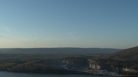 Luftaufnahmen,-Die-Klaren-Blauen-Himmel-Zeigen-Und-Nach-Unten-Schwenken,-Um-Einen-Riesigen-Steinbruch-Am-Tennessee-River-Zu-Enthüllen