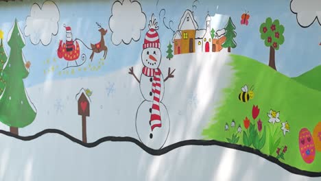 Mural-painted-on-wall-of-kindergarten-playground,-cartoon-drawings-of-seasons
