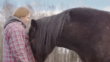 Un-Caballo-Empuja-Tiernamente-A-Una-Mujer-En-El-Pecho-Durante-Una-Sesión-De-Equinoterapia,-Vista-Lateral