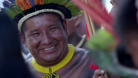 Hombre-Amazónico-Sonriente-Con-Tocado-De-Plumas-Sosteniendo-Flechas,-Cámara-Lenta